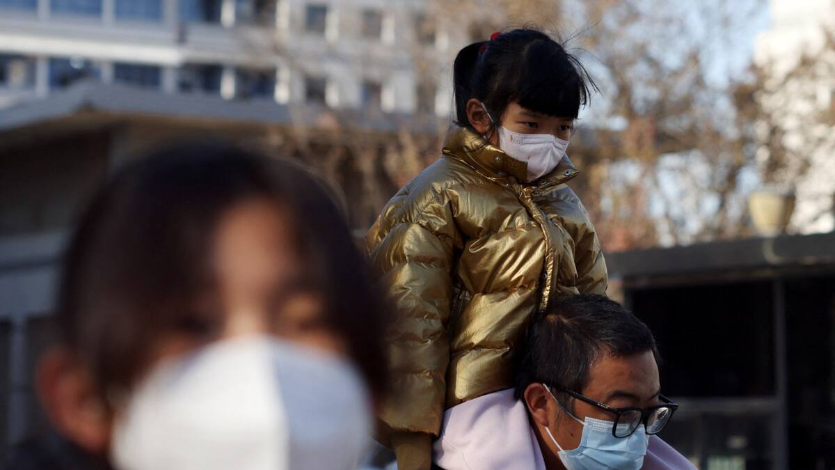 Aumentan los casos de neumonía en China. Un hombre carga a su hijo hacía el hospital. Reuters.