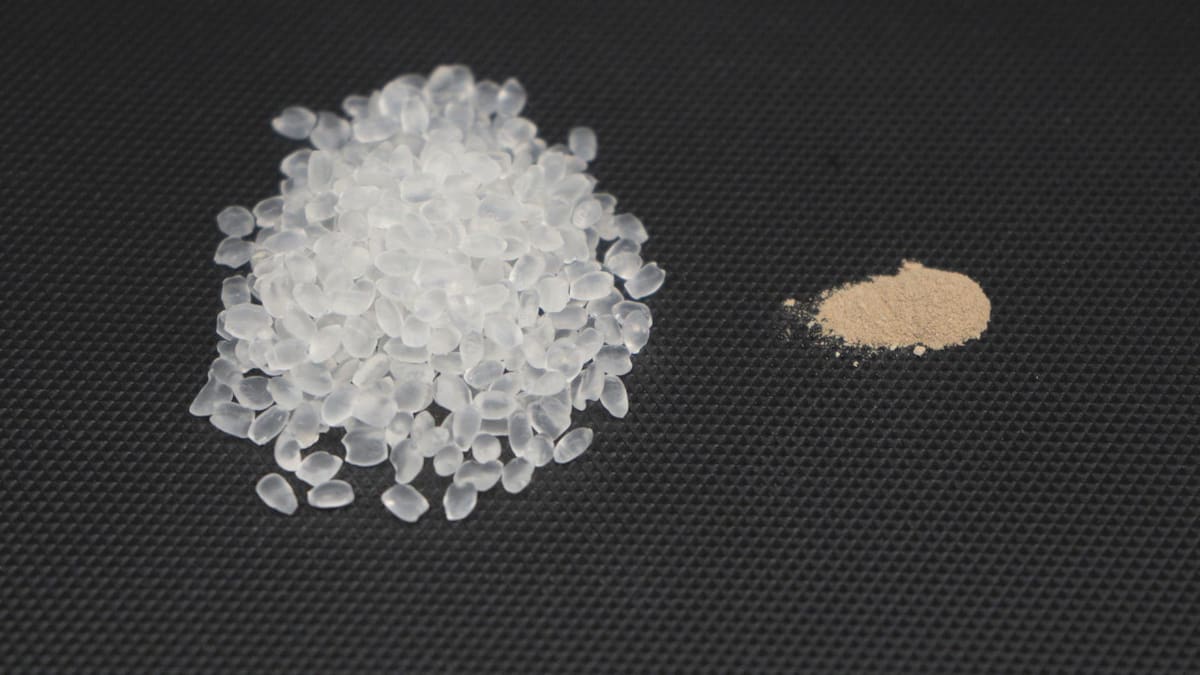 Bolitas de poliuretano termoplástico (izquierda) y polvos de esporas (derecha) que se mezclan para fabricarlo. Foto: EFE.