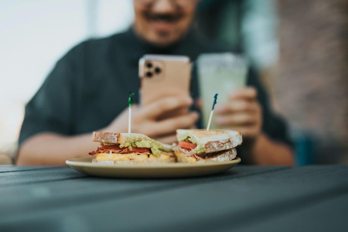 Comer con el celular, una práctica poco recomendable. Foto: Unsplash.