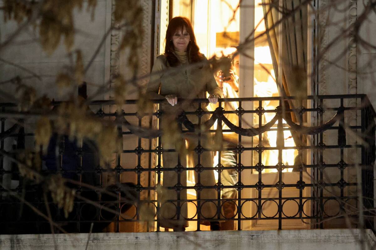 Cristina Fernández de Kirchner en el balcón de su casa, observando a los militantes que salieron a respaldarla. Foto: REUTERS/Tomas Cuesta