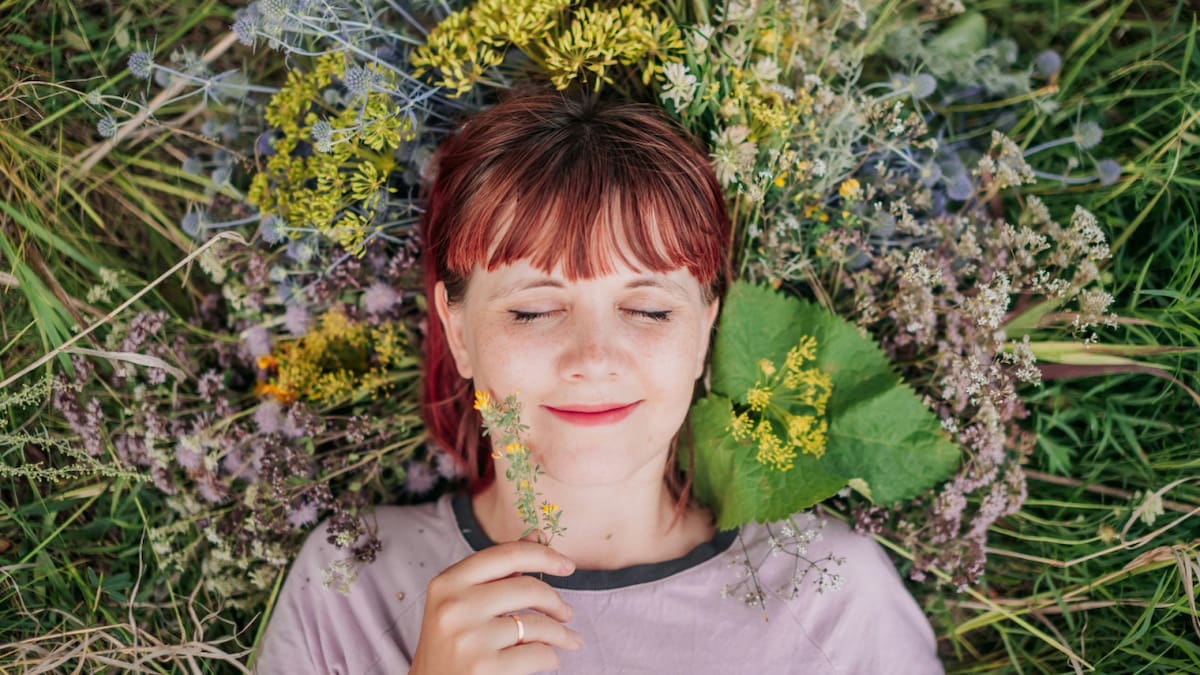 Felicidad. Una niña sonríe acostada en el pasto. Fto: Unsplash