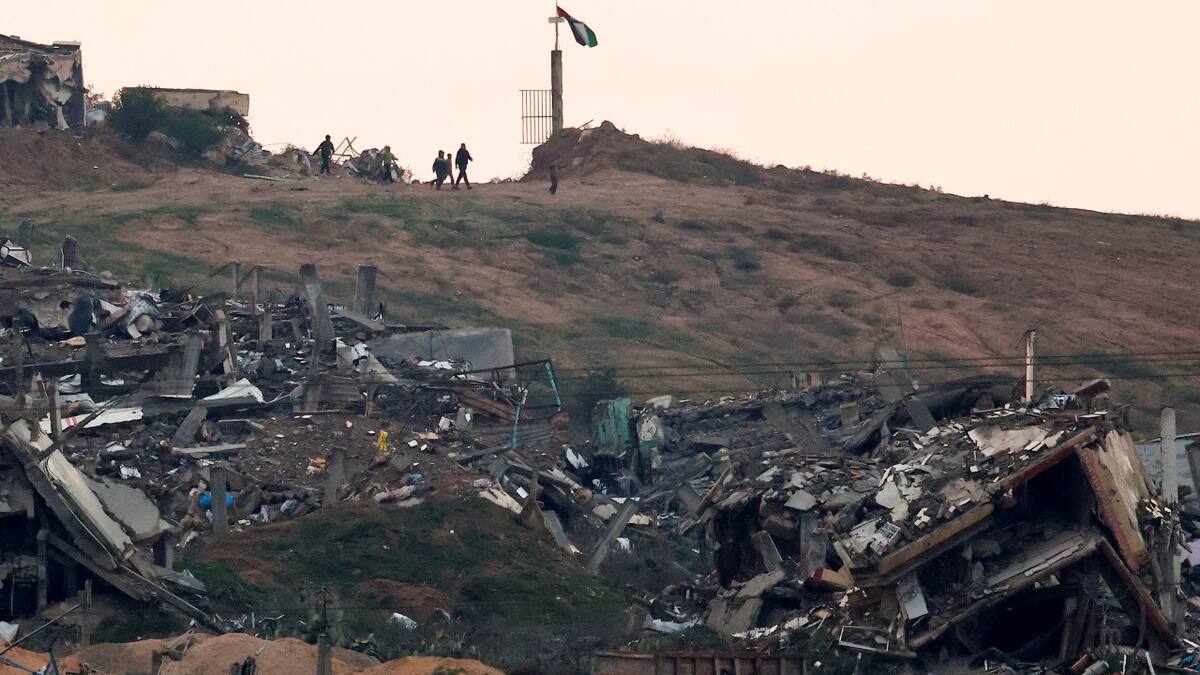 Palestinos caminan en las cercanías a ruinas en Gaza. Foto: Reuters/Amir Cohen.