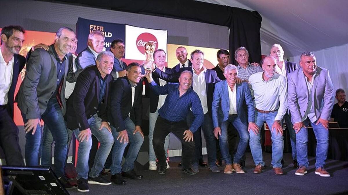 Integrantes del plantel campeón mundial del 78 y 86 posan con la Copa del Mundo en el predio de la AFA en Ezeiza