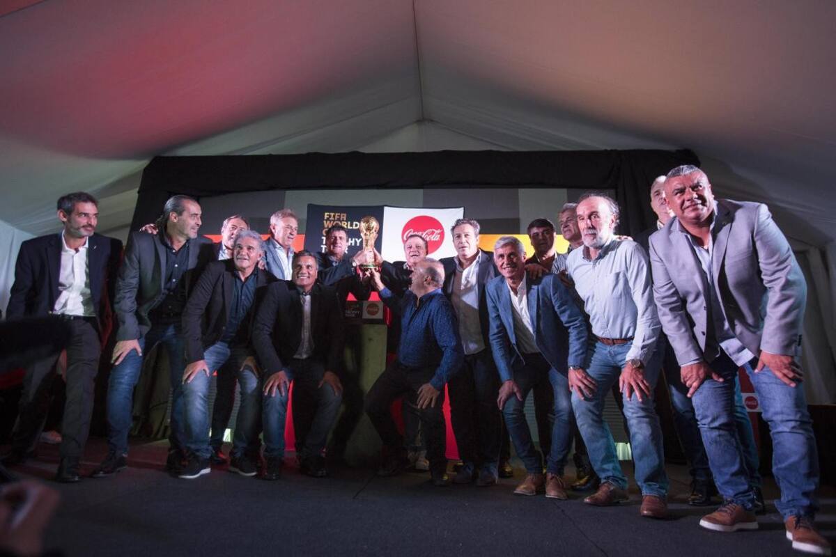 Integrantes del plantel campeón mundial del 78 y 86 posan con la Copa del Mundo en el predio de la AFA en Ezeiza