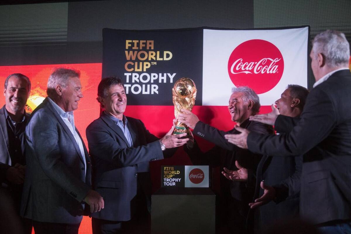 Integrantes del plantel campeón mundial del 78 y 86 posan con la Copa del Mundo en el predio de la AFA en Ezeiza