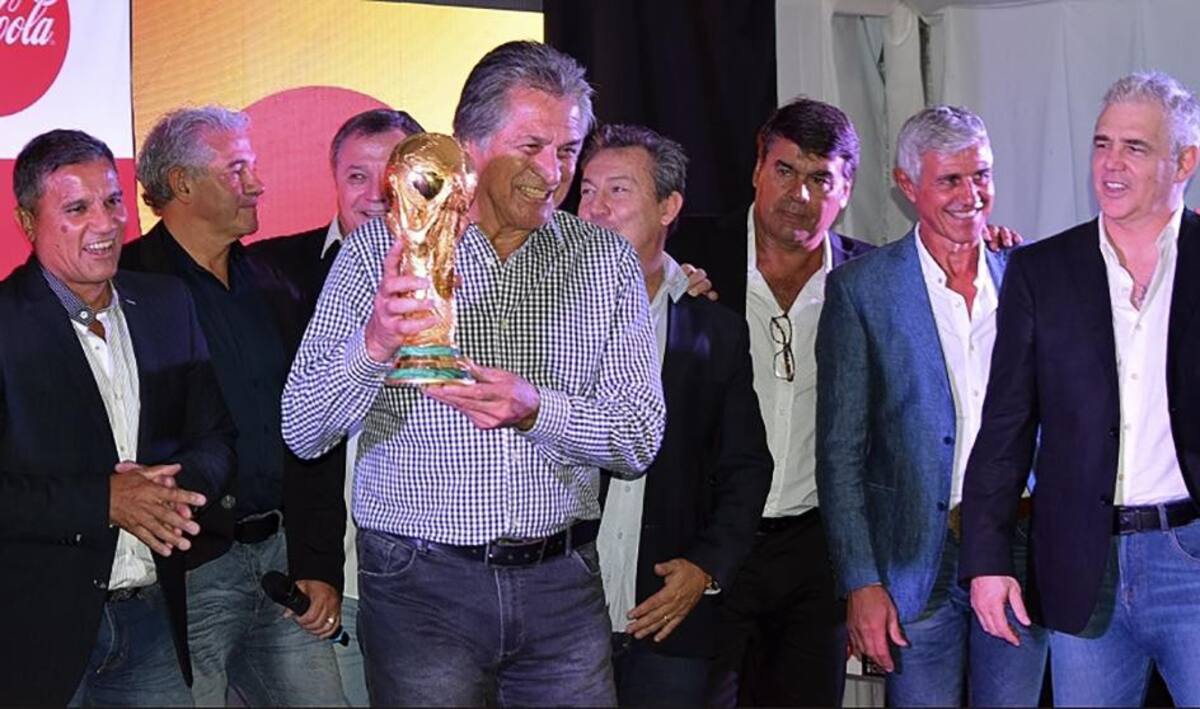 Integrantes del plantel campeón mundial del 78 y 86 posan con la Copa del Mundo en el predio de la AFA en Ezeiza