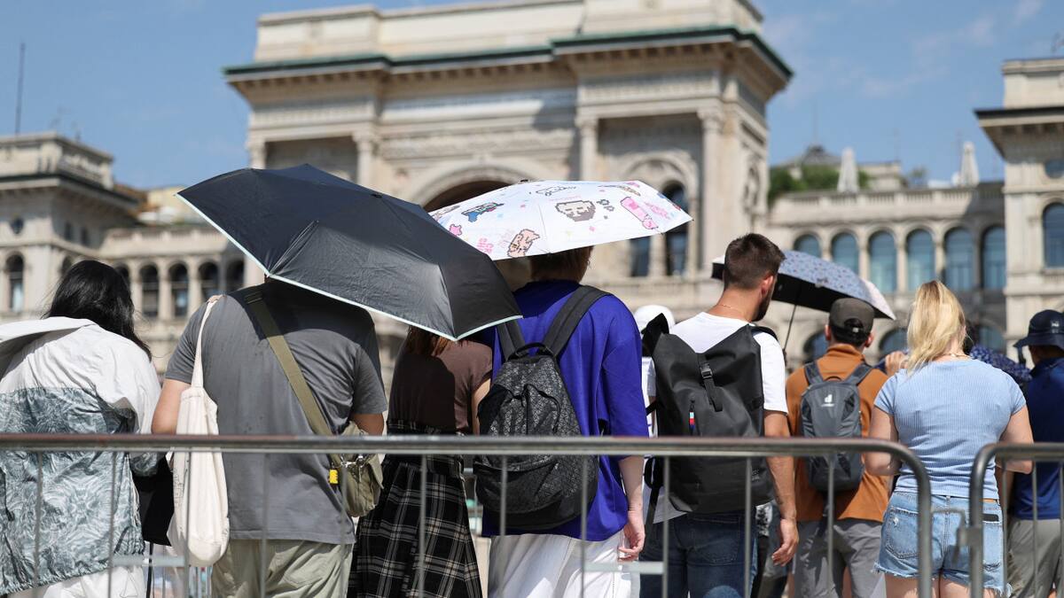 La gente usa sombrillas para esconderse del sol, mientras hacen cola para entrar en la Catedral del Duomo de Milán, durante una ola de calor. Foto: Reuters.