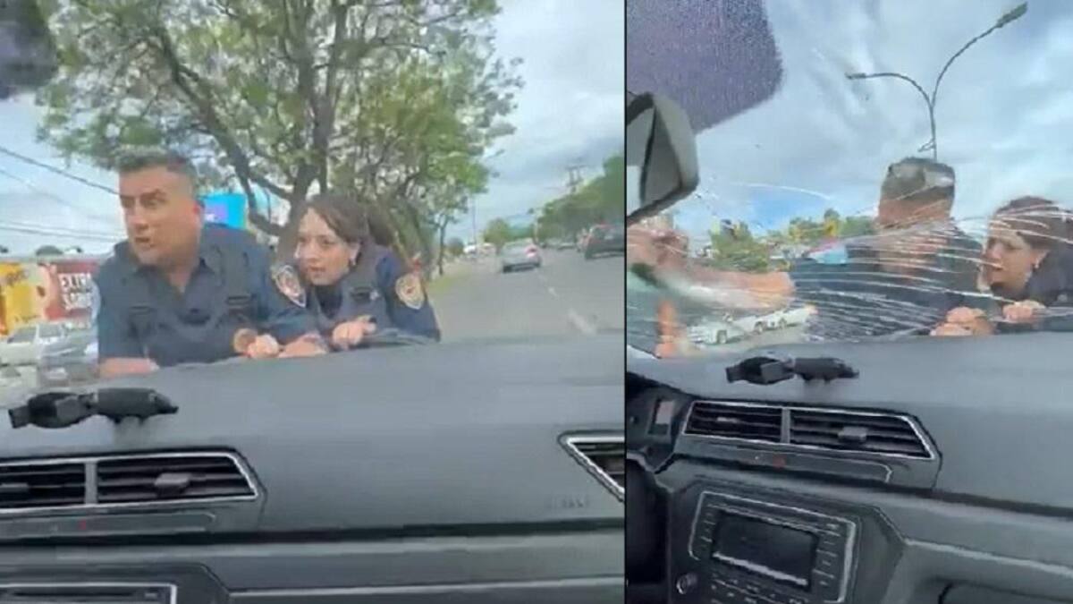 Los agentes sobre el capot. Fotos: captura de video.