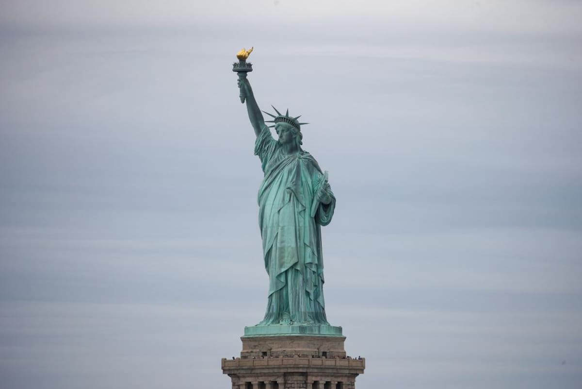 Mujer protesta en la Estatua de la Libertad, Reuters
