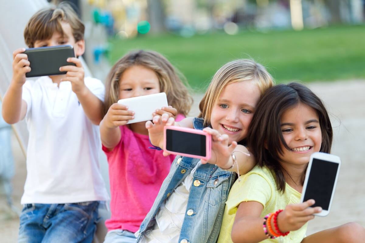 Niños usando el celular. Foto Freepik