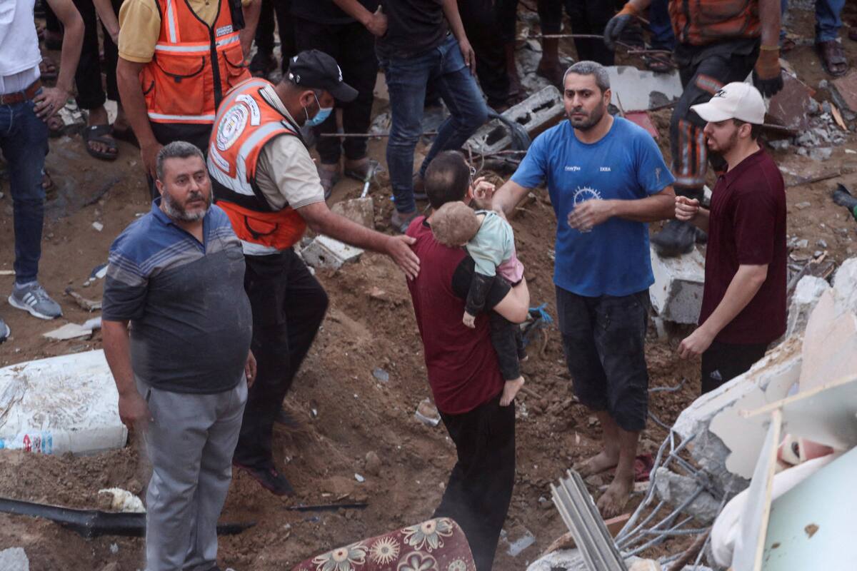 Palestinos encuentran un niño en los escombros luego de un bombardeo a una estructura residencial en Gaza. Reuters.