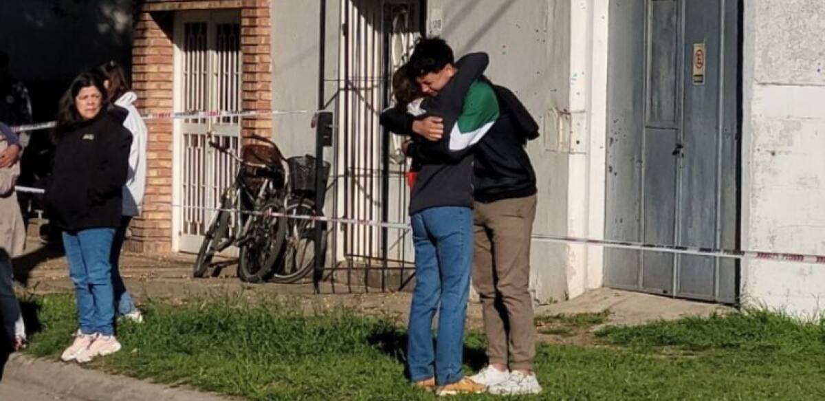 Un allegado consuela a uno de los hijos de la mujer. Foto: NA