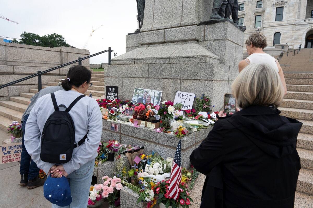 Un grupo de personas visita un monumento conmemorativo frente al Capitolio del estado de Minnesota en honor de la asambleísta estatal demócrata Melissa Hortman y su marido Mark. Foto: Reuters / Tim Evans.