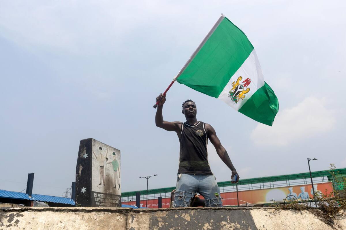 Un hombre ondea la bandera nacional nigeriana. Foto: EFE.