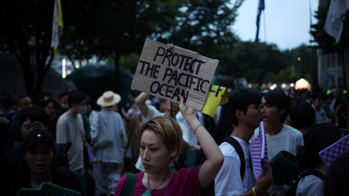 Una mujer sostiene una pancarta durante una protesta contra el plan de Japón de liberar al océano aguas residuales tratadas de la central nuclear de Fukushima. Foto: Reuters.