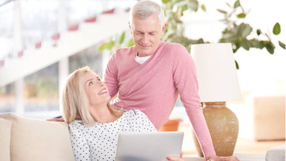 Una pareja de adultos usando computadoras.