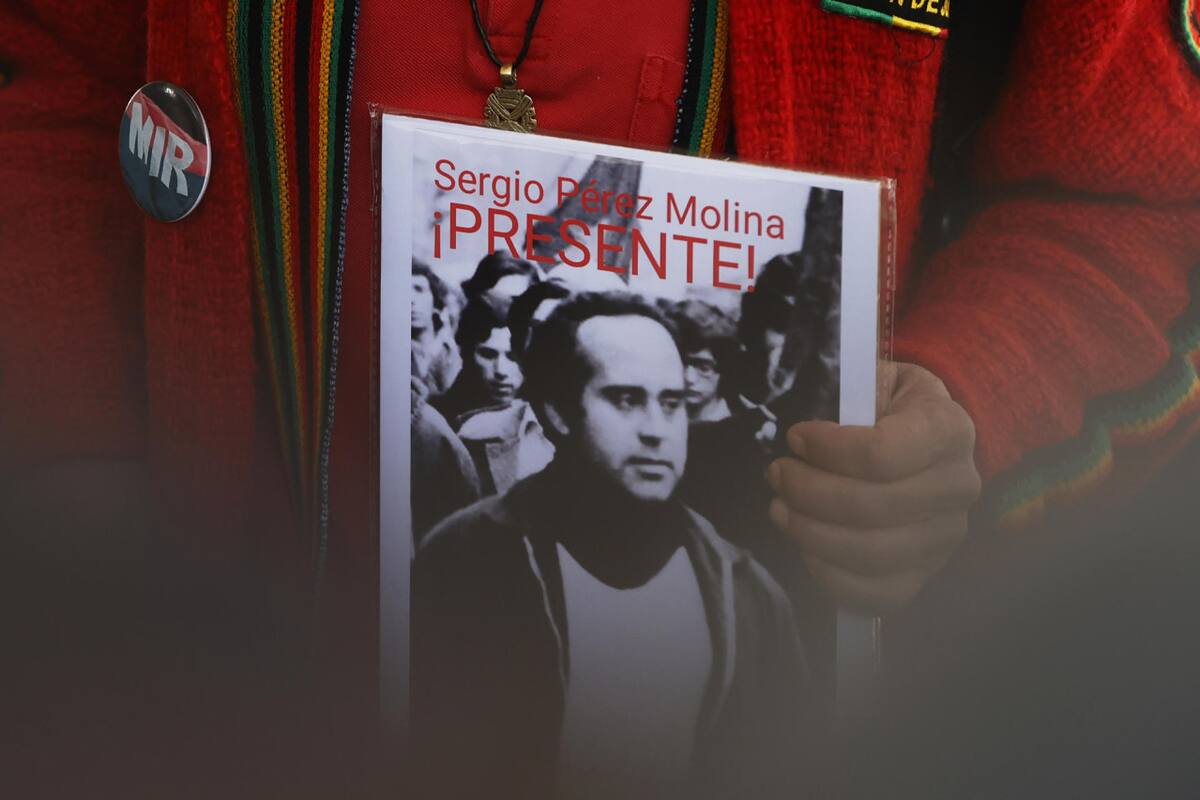 Una persona sostiene la fotografía de una persona desaparecida durante la dictadura de Augusto Pinochet. Foto: EFE.